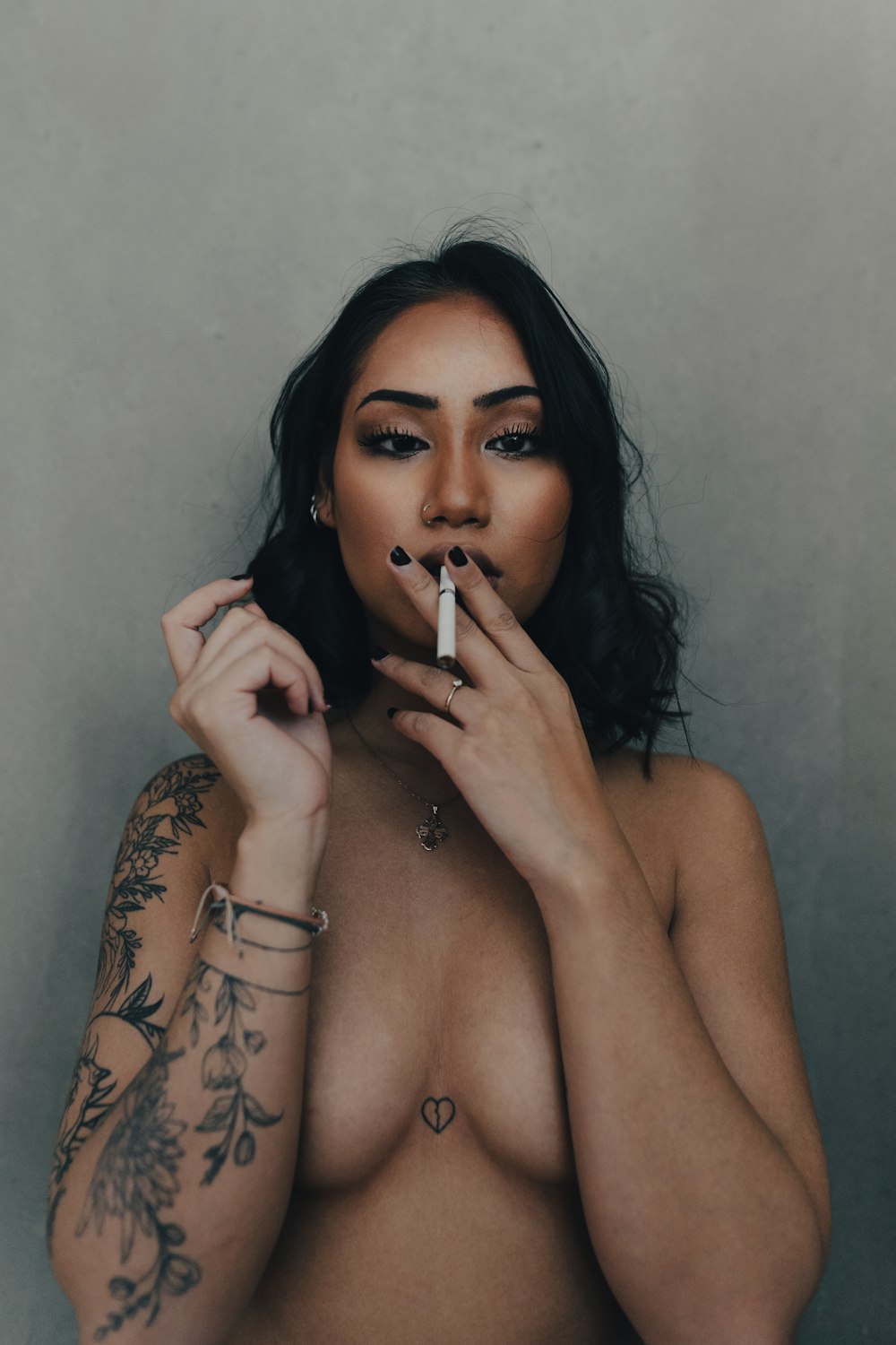 topless woman holding cigarette stick
