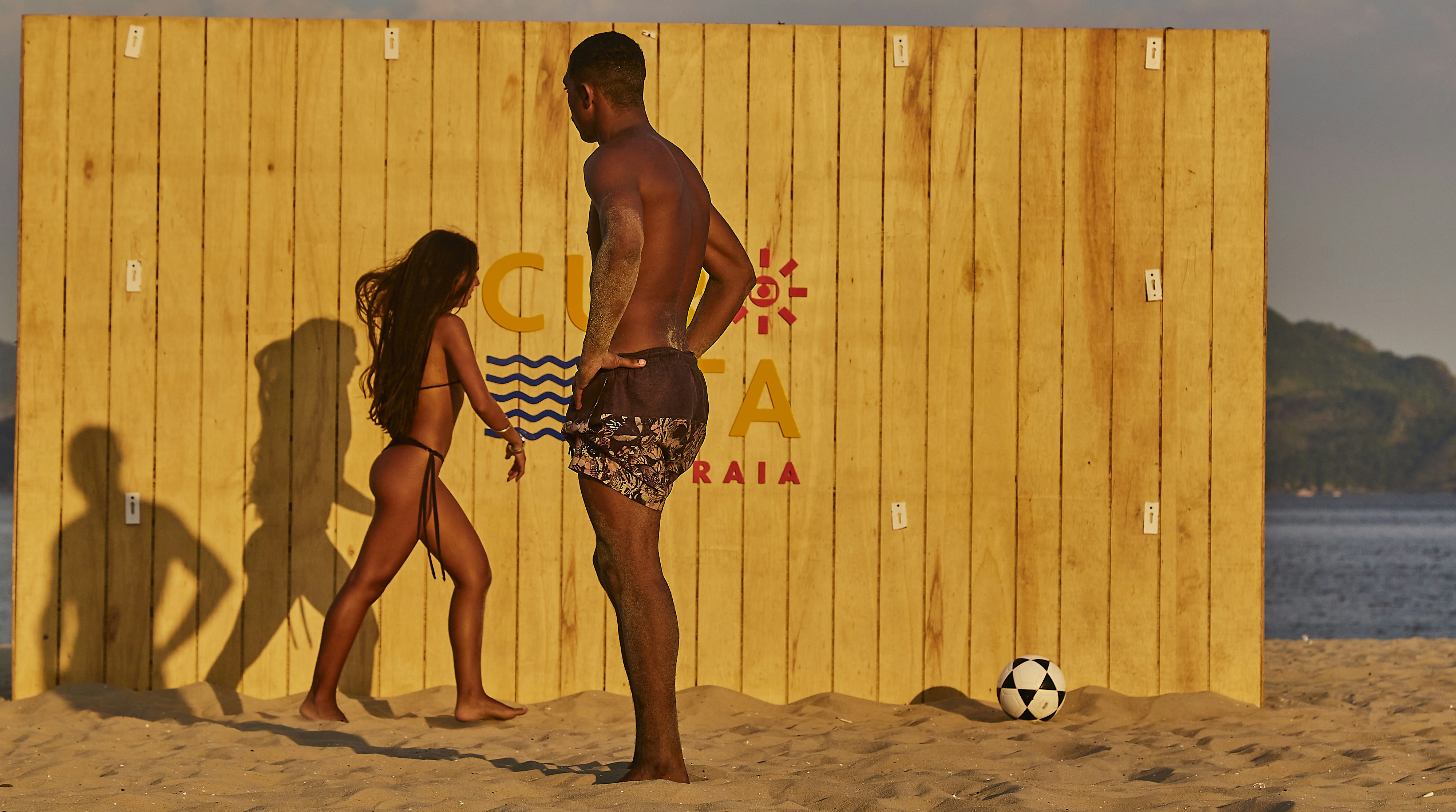 man and woman standing on beach during daytime