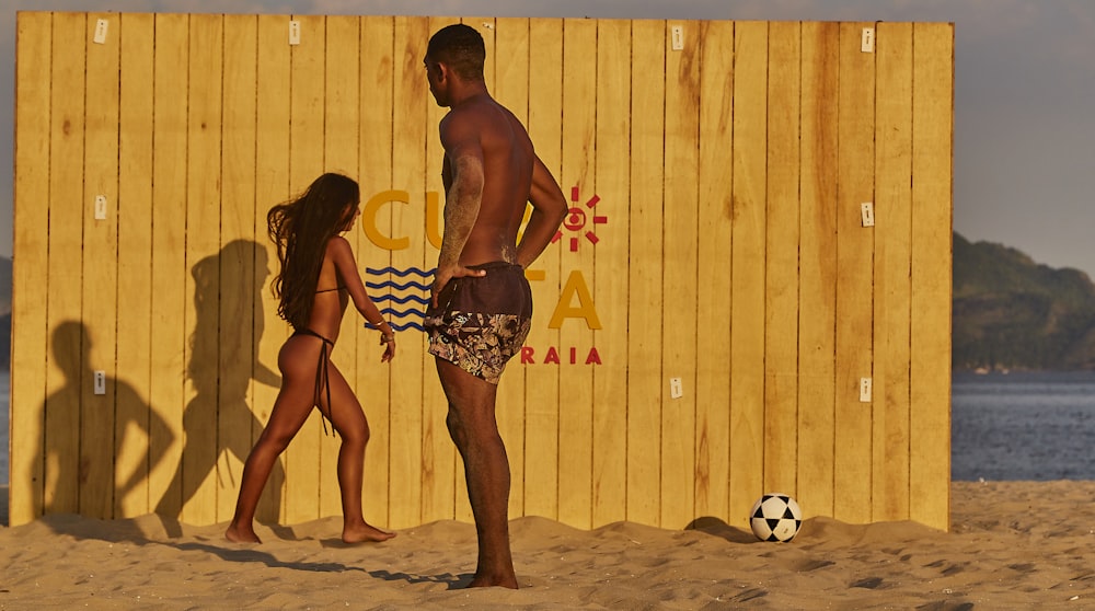 man and woman standing on beach during daytime