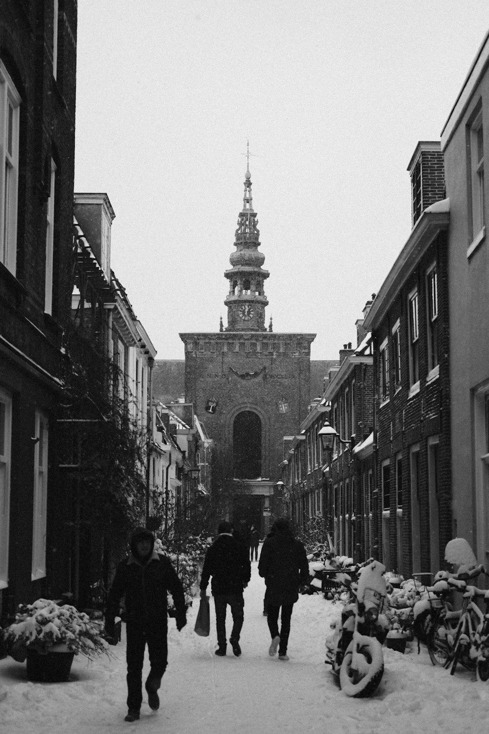 a group of people walking down a snow covered street