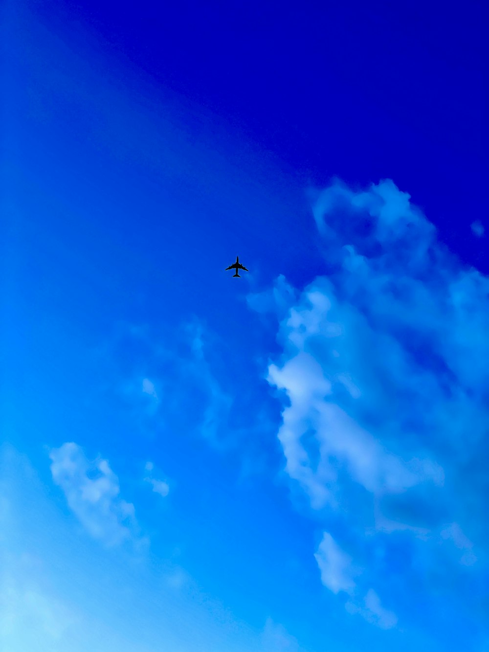 昼間の青空の下、空中を飛ぶ飛行機