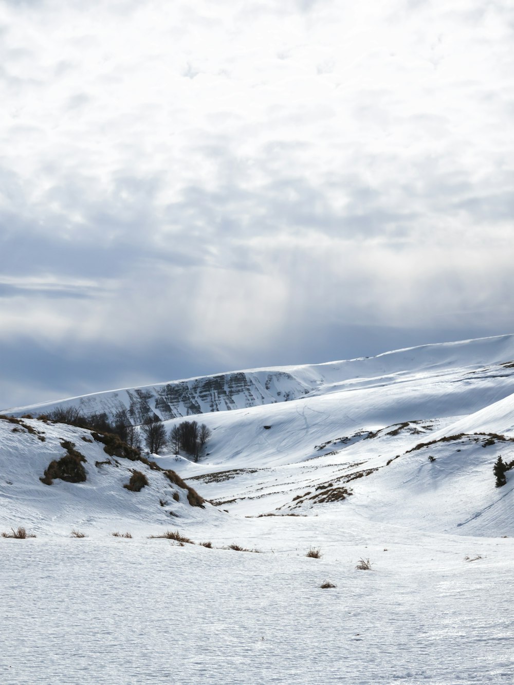 Schneebedeckter Berg tagsüber unter bewölktem Himmel