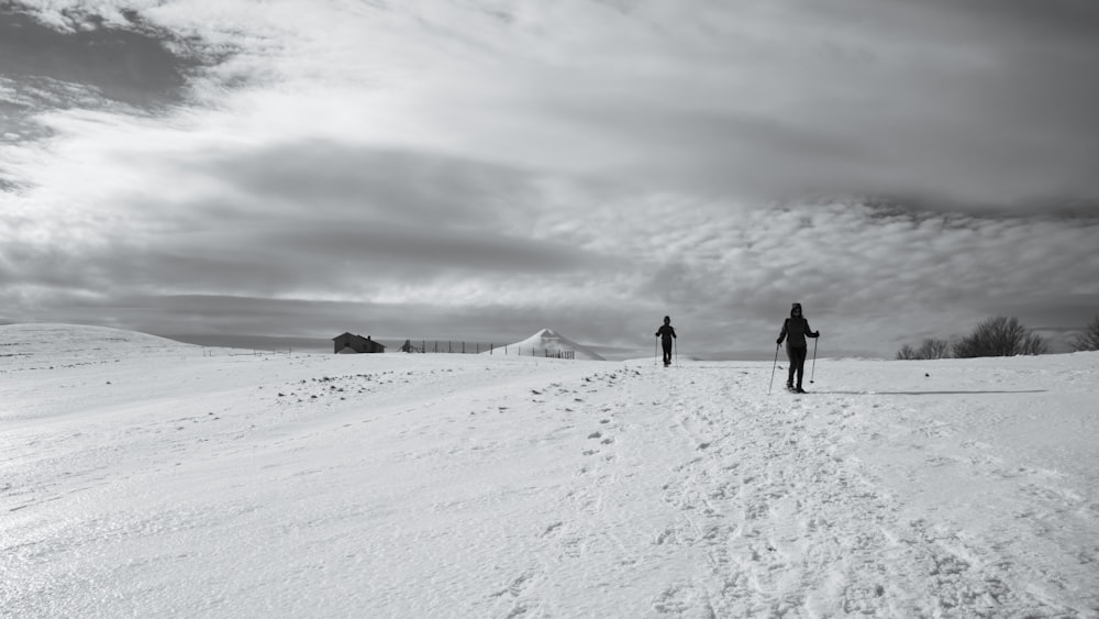 2 persone che camminano su un terreno innevato durante il giorno