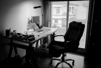black office rolling chair near white wooden desk