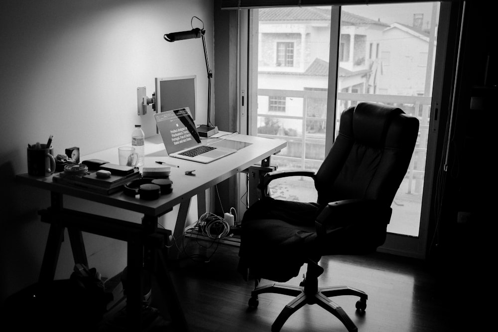 black office rolling chair near white wooden desk