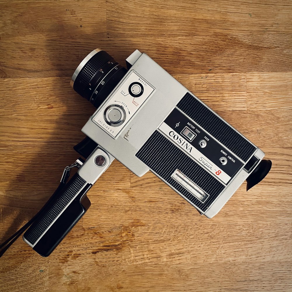 black and silver camera on brown wooden table