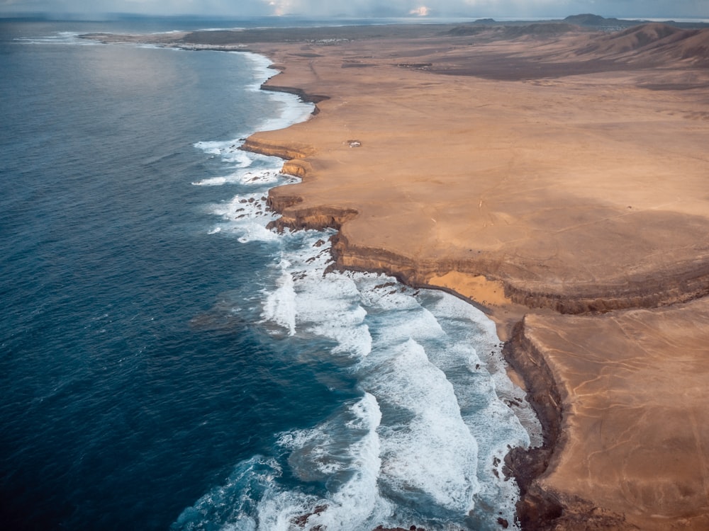 Vue aérienne des vagues de l’océan qui s’écrasent sur le rivage pendant la journée