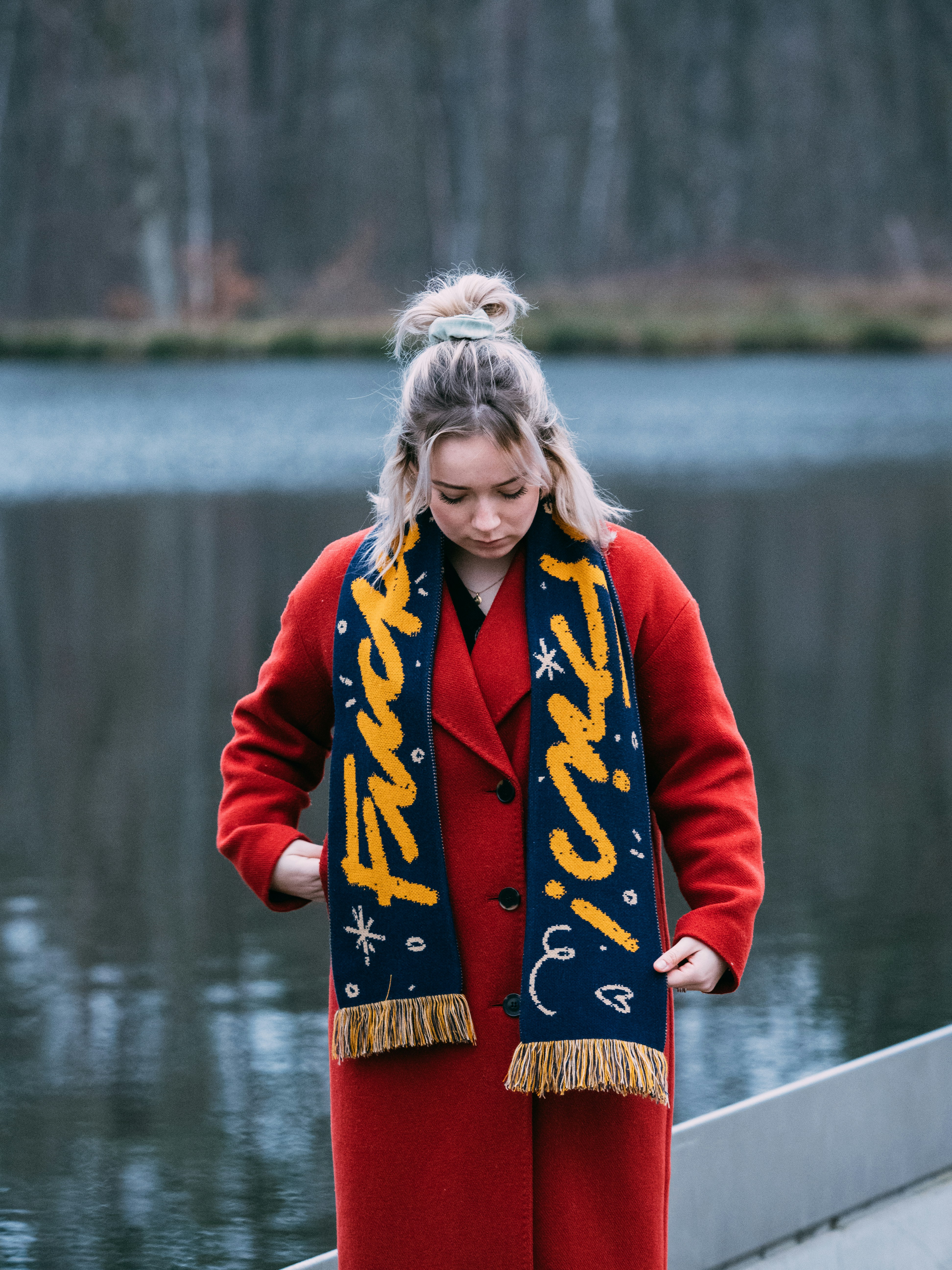 woman in red jacket standing on dock during daytime