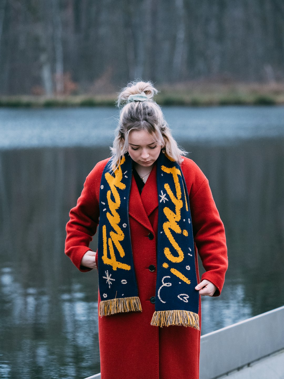 woman in red jacket standing on dock during daytime