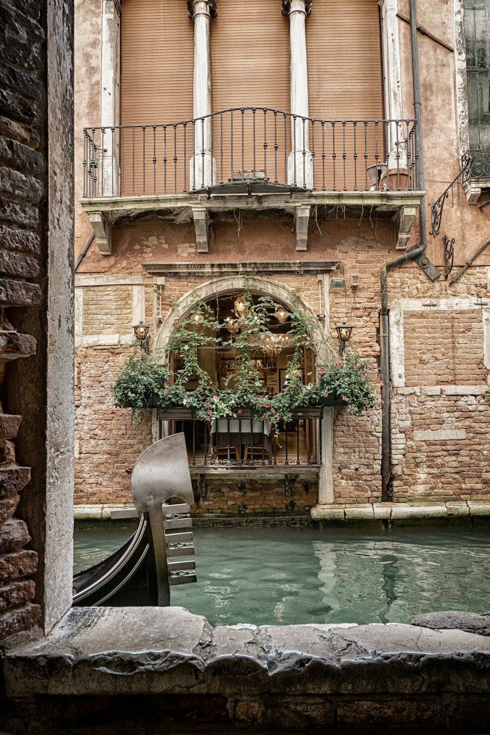 black boat on river in between brick building during daytime