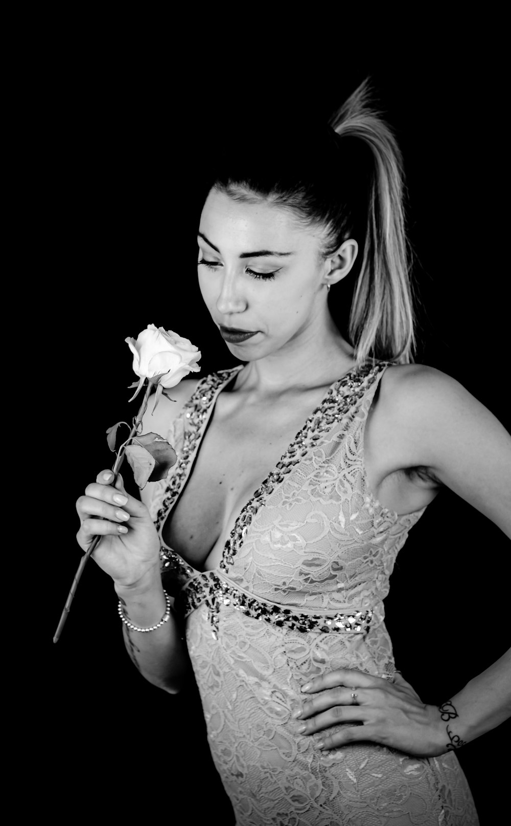 woman in white and black floral tank top holding yellow flower