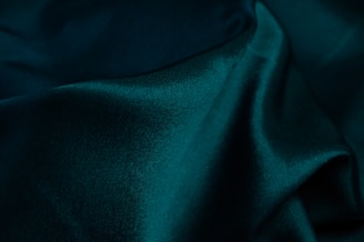 Deep green pigment powder forming a smooth pile on a dark surface.