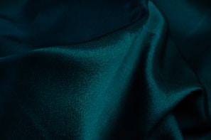 Deep green pigment powder forming a smooth pile on a dark surface.