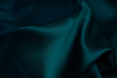 Sage green hemp fabric draped to reveal its sturdy yet breathable quality.