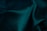 Dark green fabric with a smooth texture and soft folds creating gentle contours and shadows.