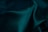 Dark green fabric with a smooth texture and soft folds creating gentle contours and shadows.