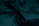 Close-up of a customer gently touching a rich emerald green textured fabric at the store.