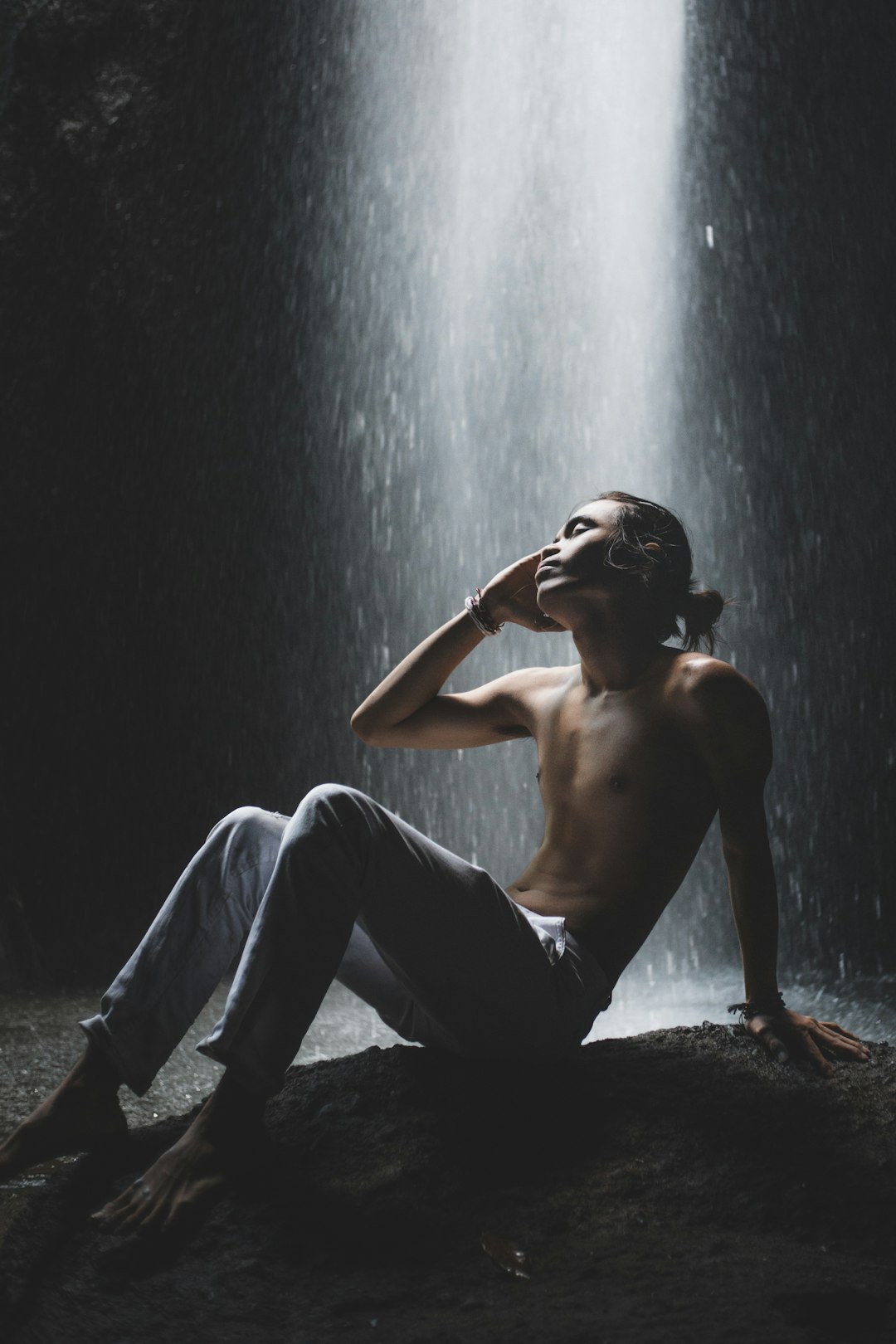 topless man in blue denim jeans sitting on ground