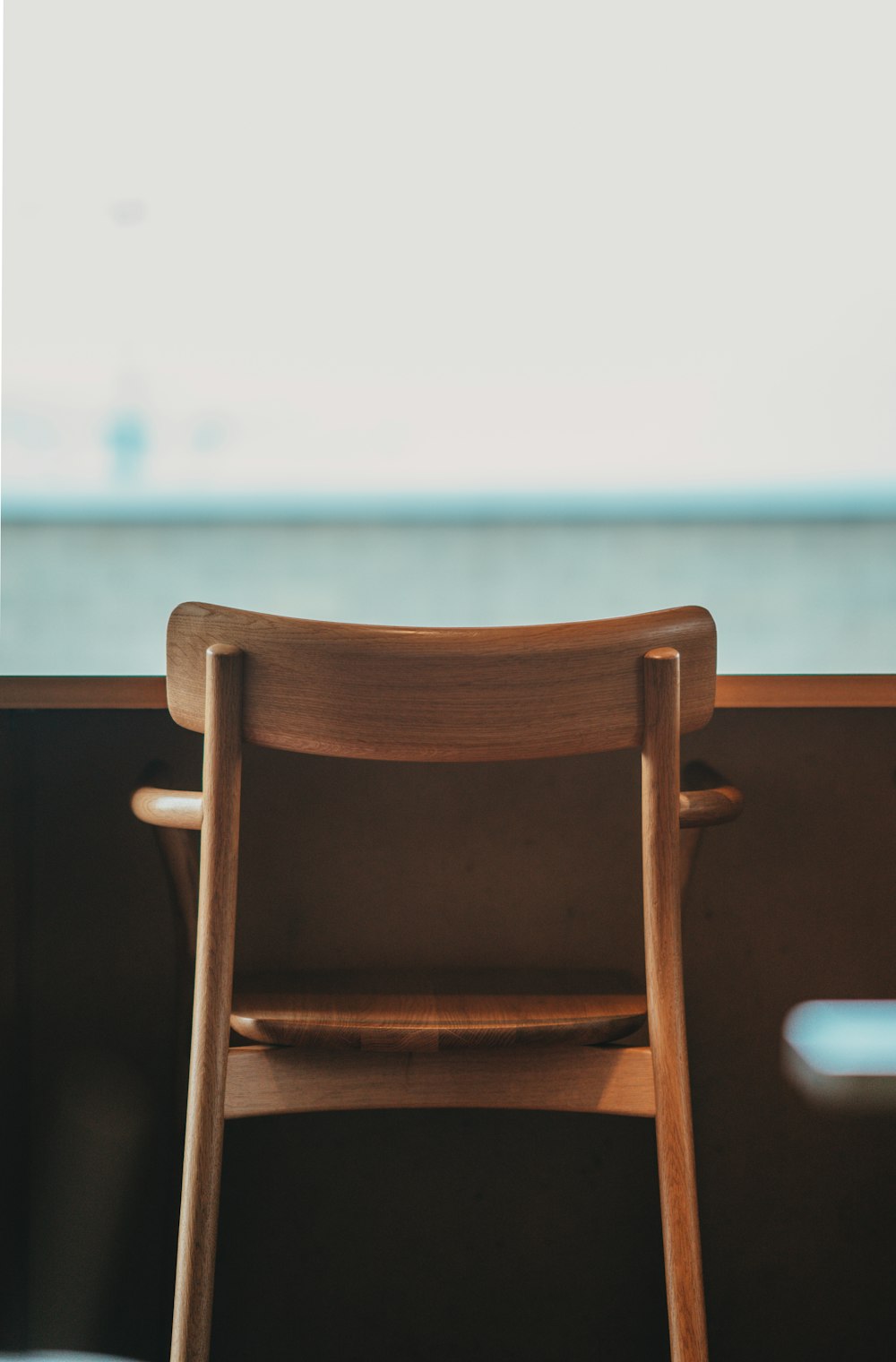 brown wooden chair near white wall