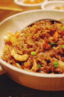 brown and green food in white ceramic bowl