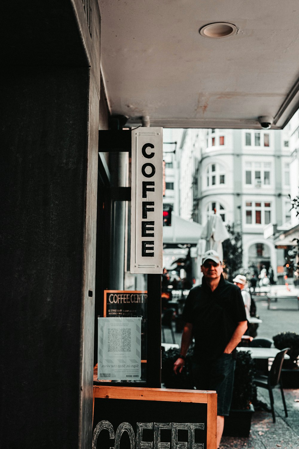 Mann in schwarzem T-Shirt und schwarzer Hose sitzt auf schwarzem Rollstuhl