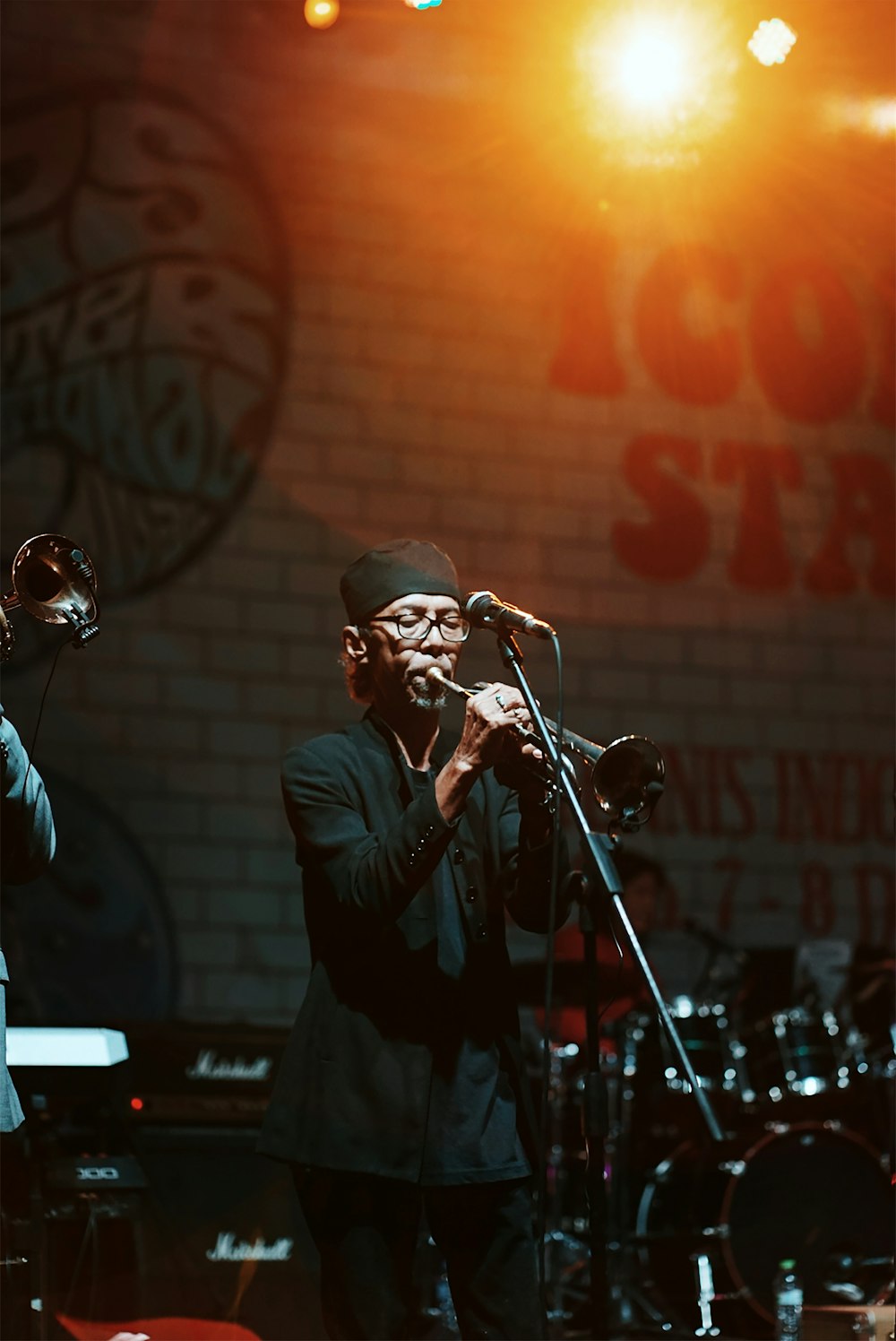 man in black suit singing on stage