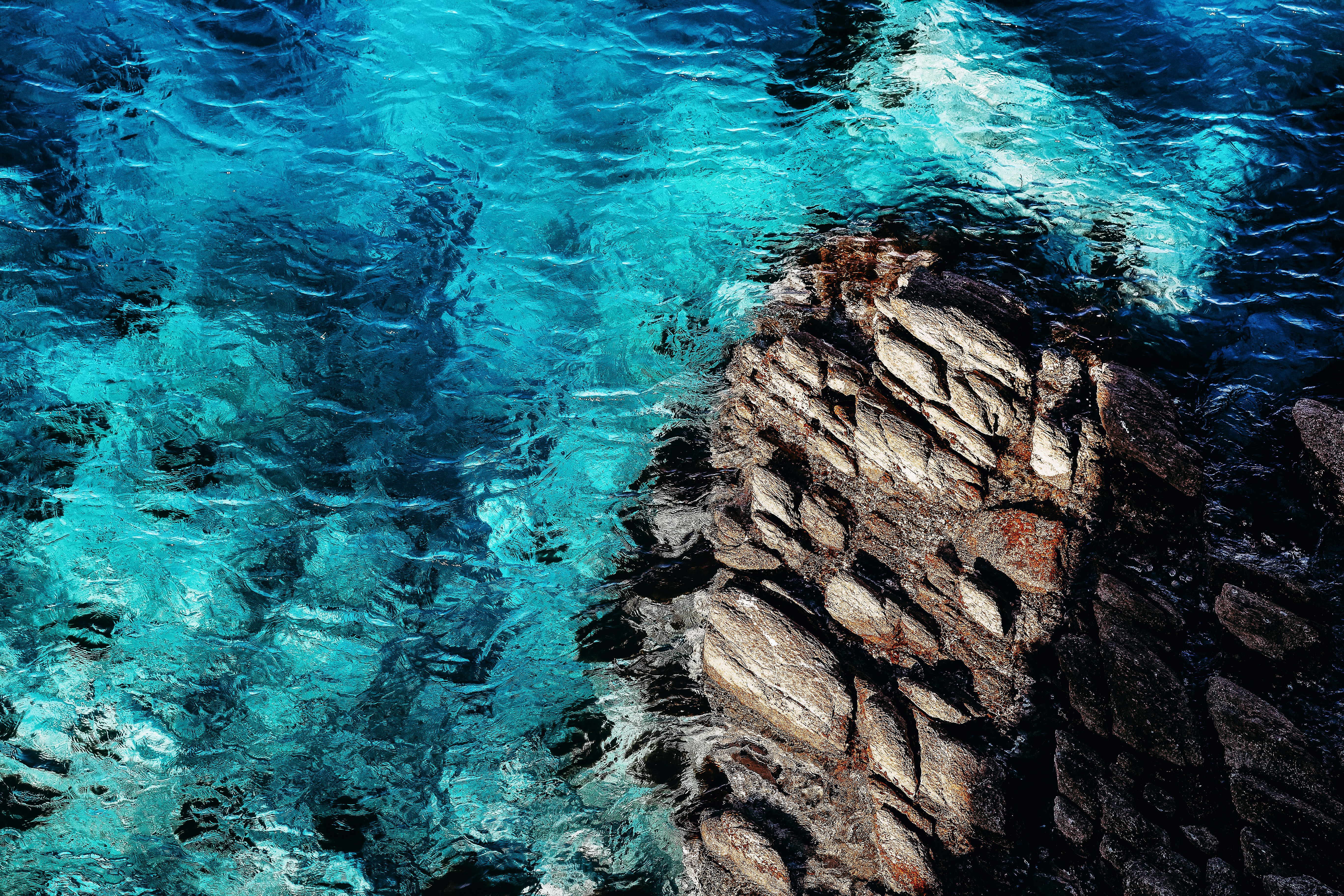 brown rock formation beside body of water during daytime