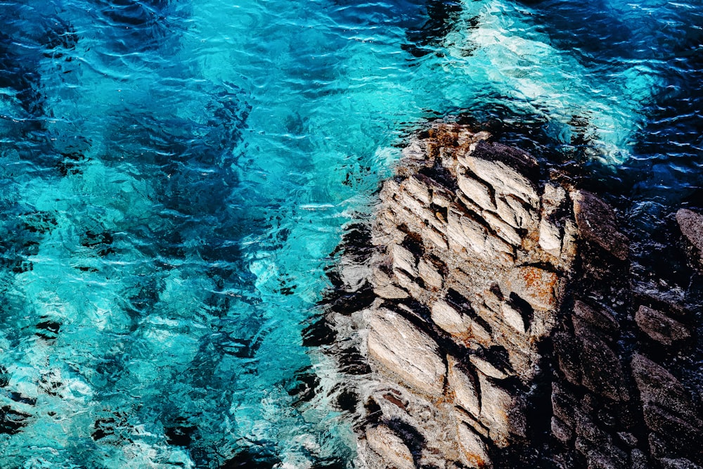 brown rock formation beside body of water during daytime