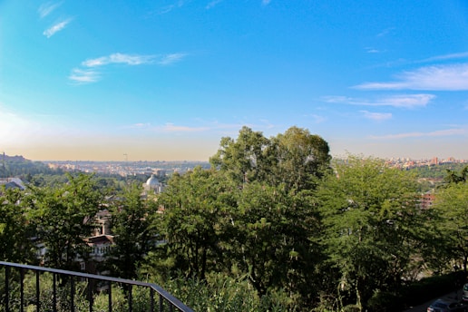 A vibrant aerial view of a bustling city neighborhood with modern homes and green spaces under a clear sky.