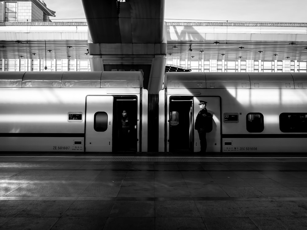 grayscale photo of people in train station