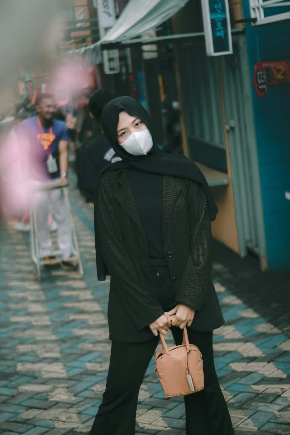 woman in black coat standing on sidewalk