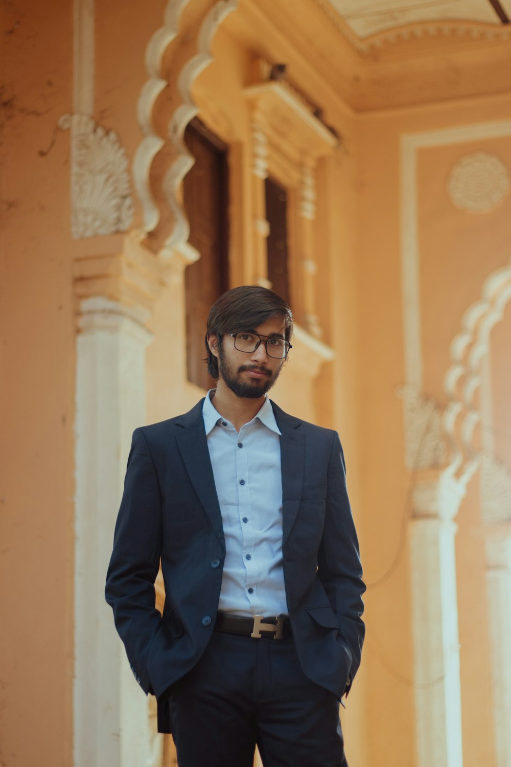 a man in a suit standing in front of a building