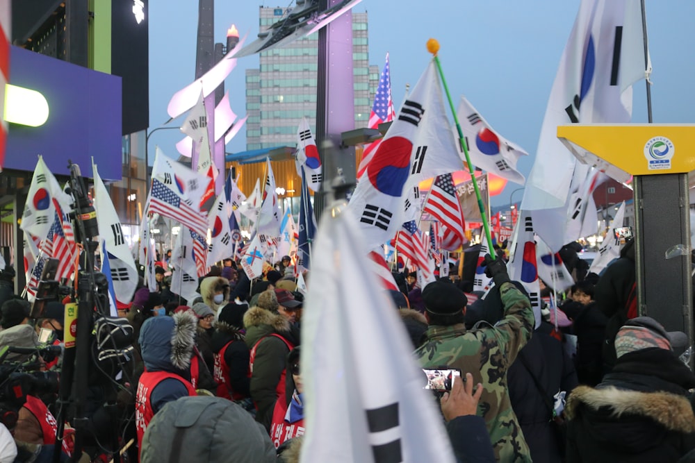 people gathering in a street with flags during daytime