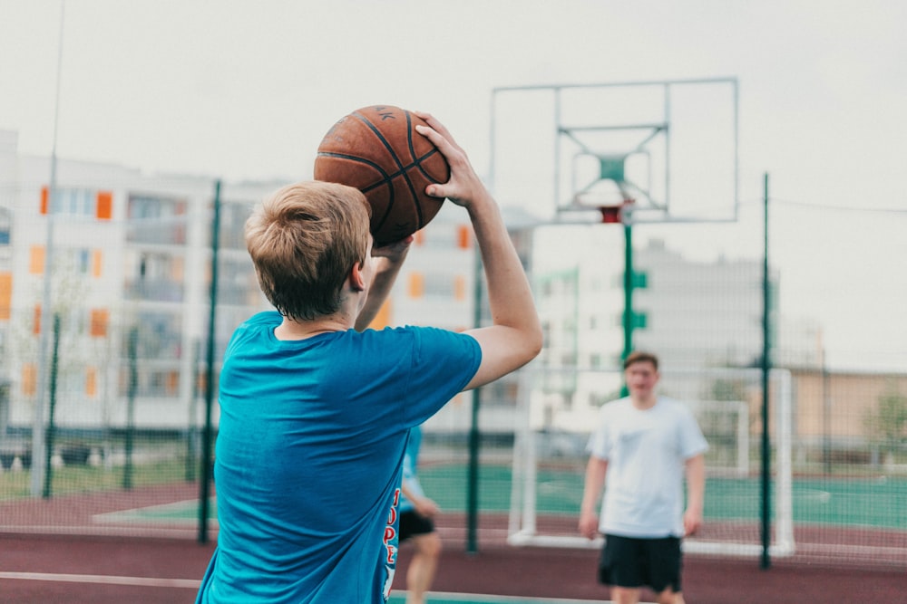 man in blue t-shirt holding basketball