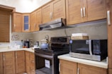 white microwave oven on brown wooden kitchen cabinet