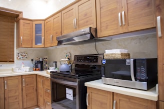 white microwave oven on brown wooden kitchen cabinet