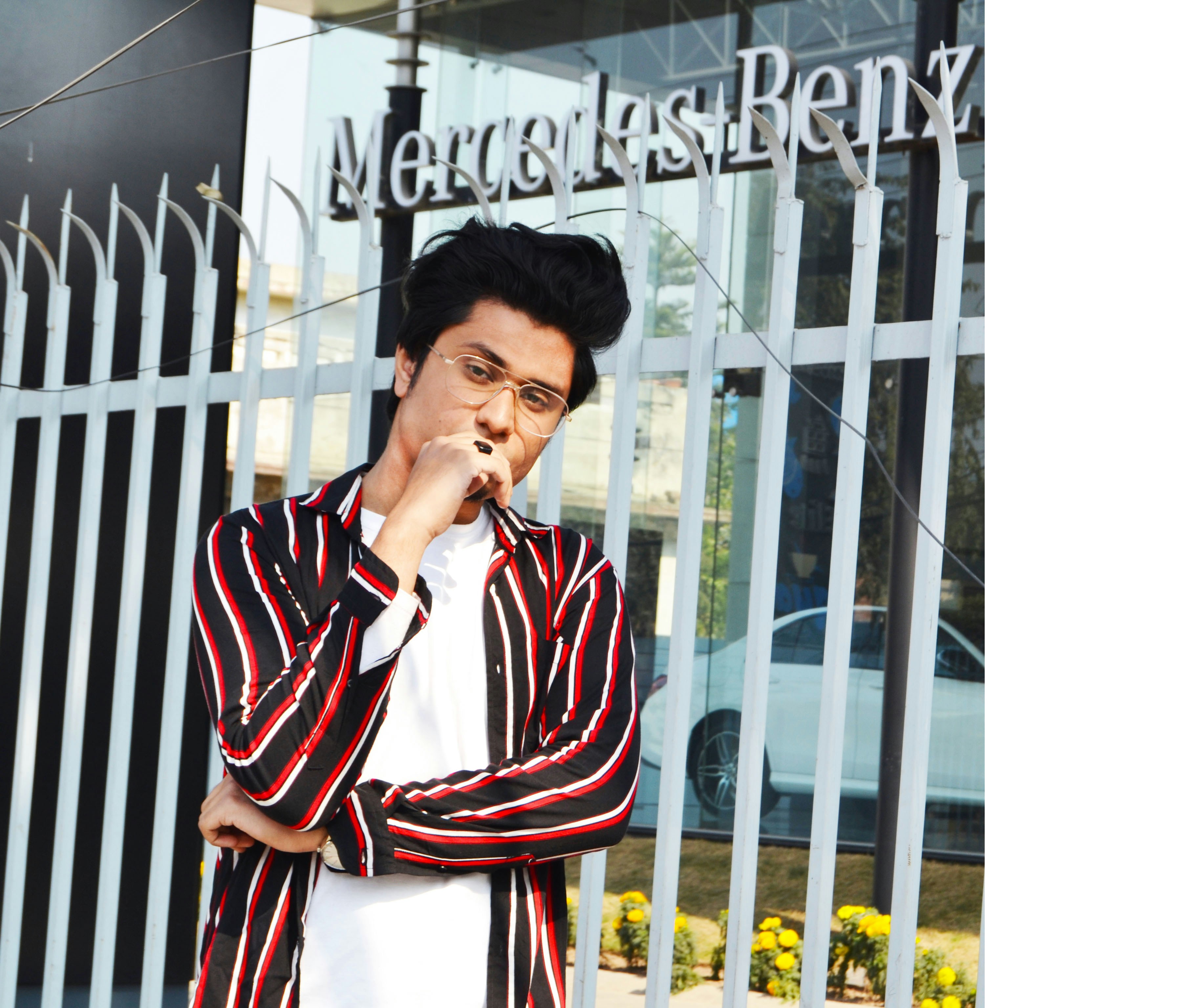 man in red and white stripe long sleeve shirt standing beside white wooden fence during daytime