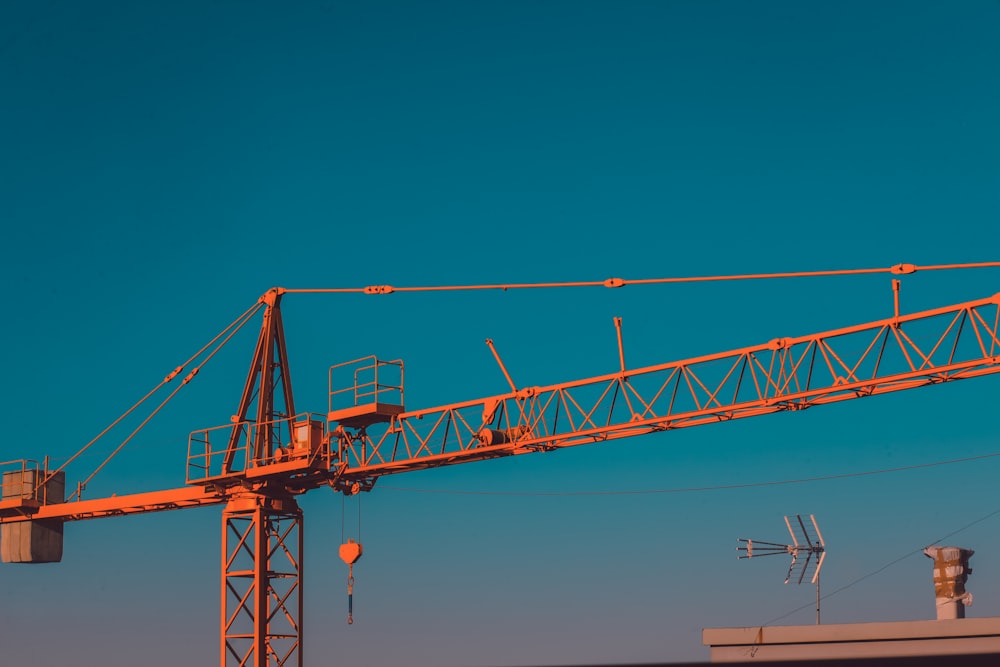 orange crane under blue sky during daytime