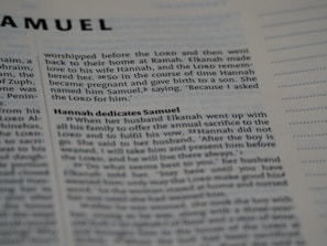 A close-up photo of a Bible page, showing the text from the book of Samuel. The passage discusses Hannah and her son, Samuel. The text is in English and the focus is on a specific scripture narrative.