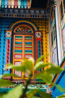 A vibrant window painted with colorful floral designs that catch the sunlight beautifully.
