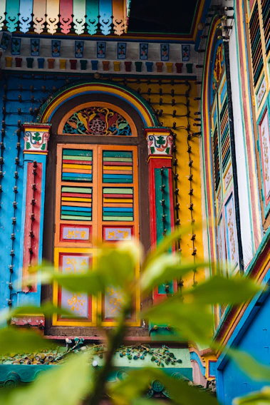 A vibrant window painted with colorful floral designs that catch the sunlight beautifully.