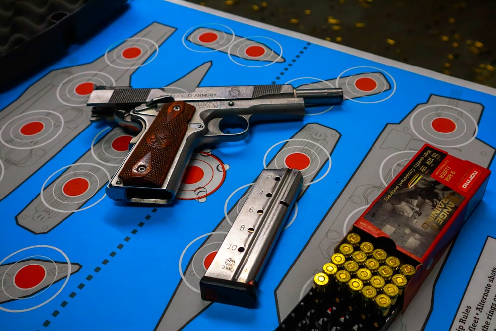 gray and black semi automatic pistol on blue and white book