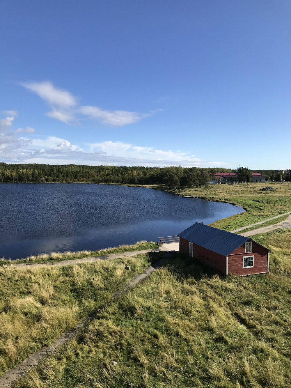 brown wooden house near lake under blue sky during daytime