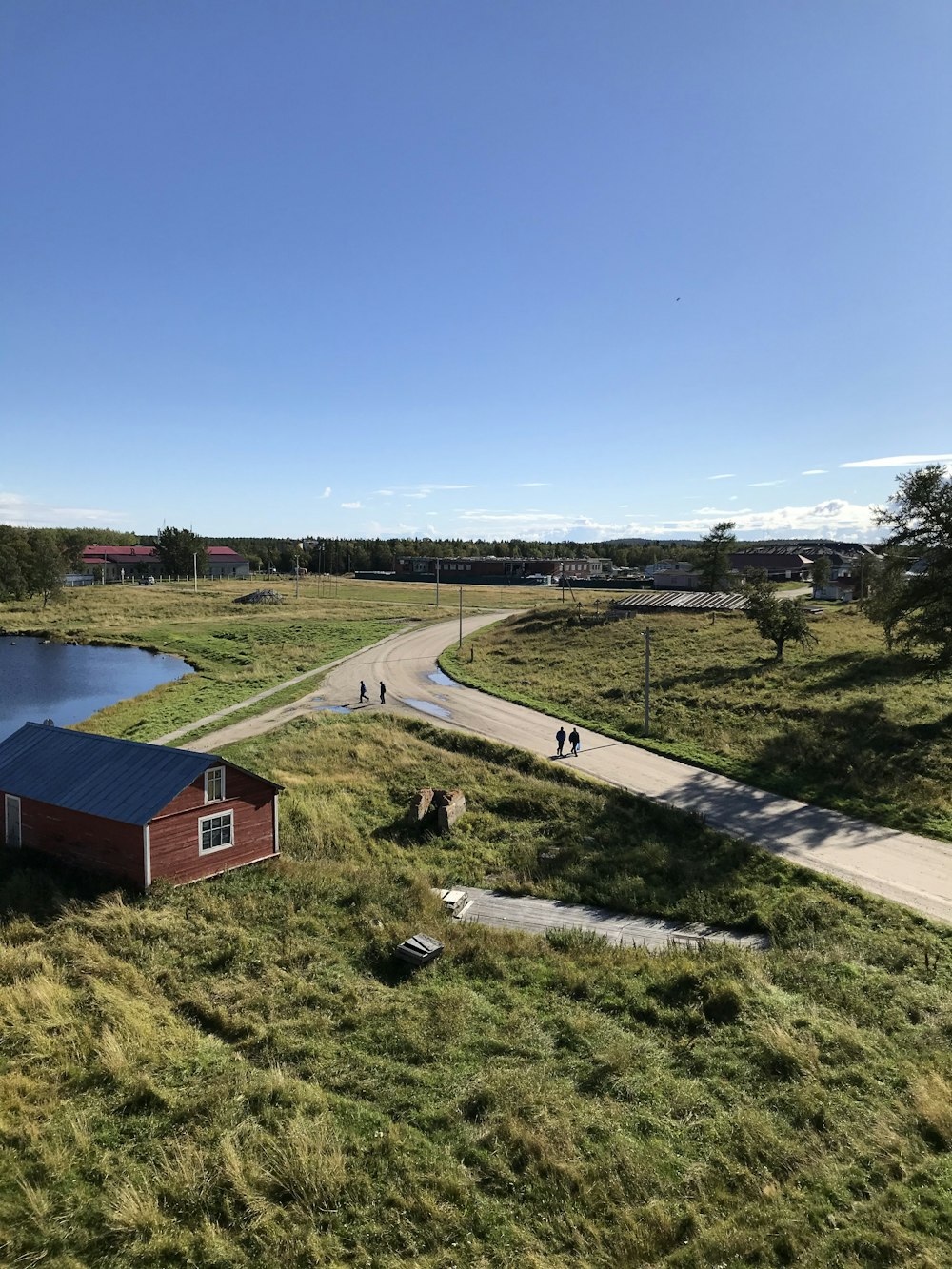 Casa marrón y blanca cerca de campo de hierba verde bajo el cielo azul durante el día