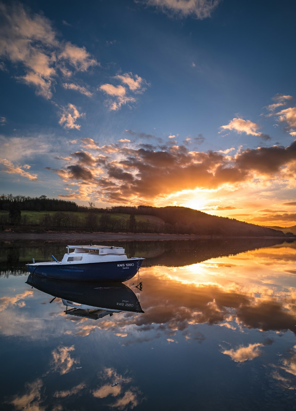 white and black boat on water during sunset