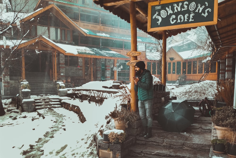 woman in black jacket and brown hat standing on snow covered ground during daytime