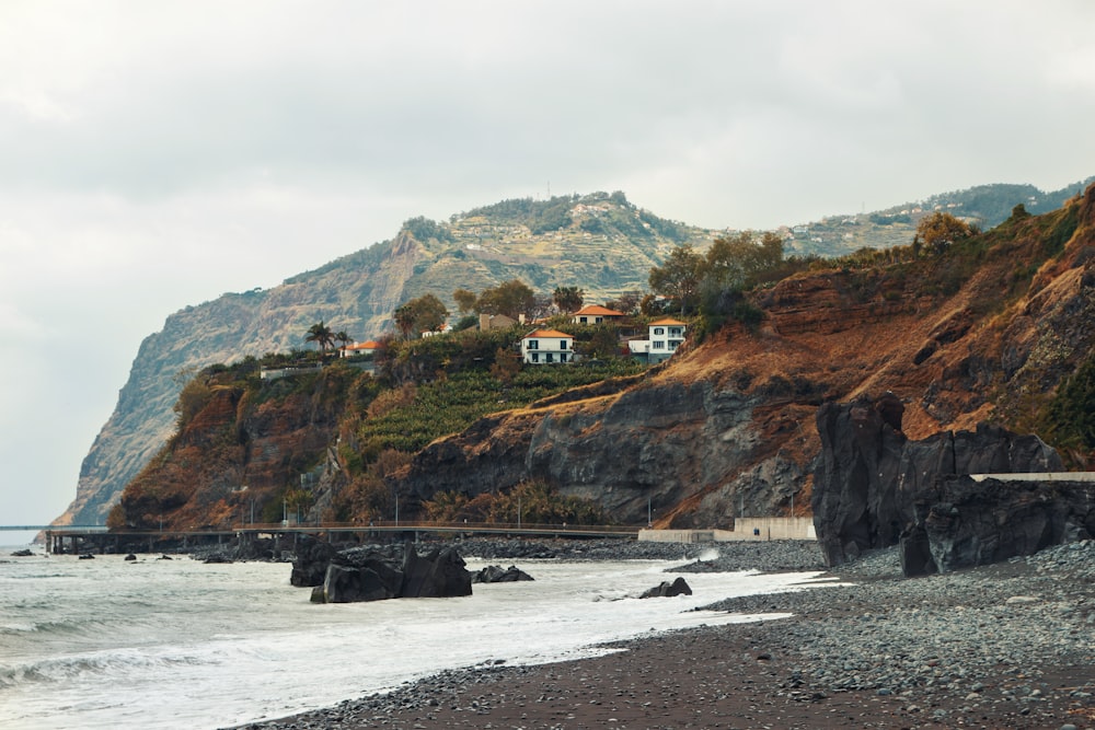 brown and green mountain beside body of water during daytime