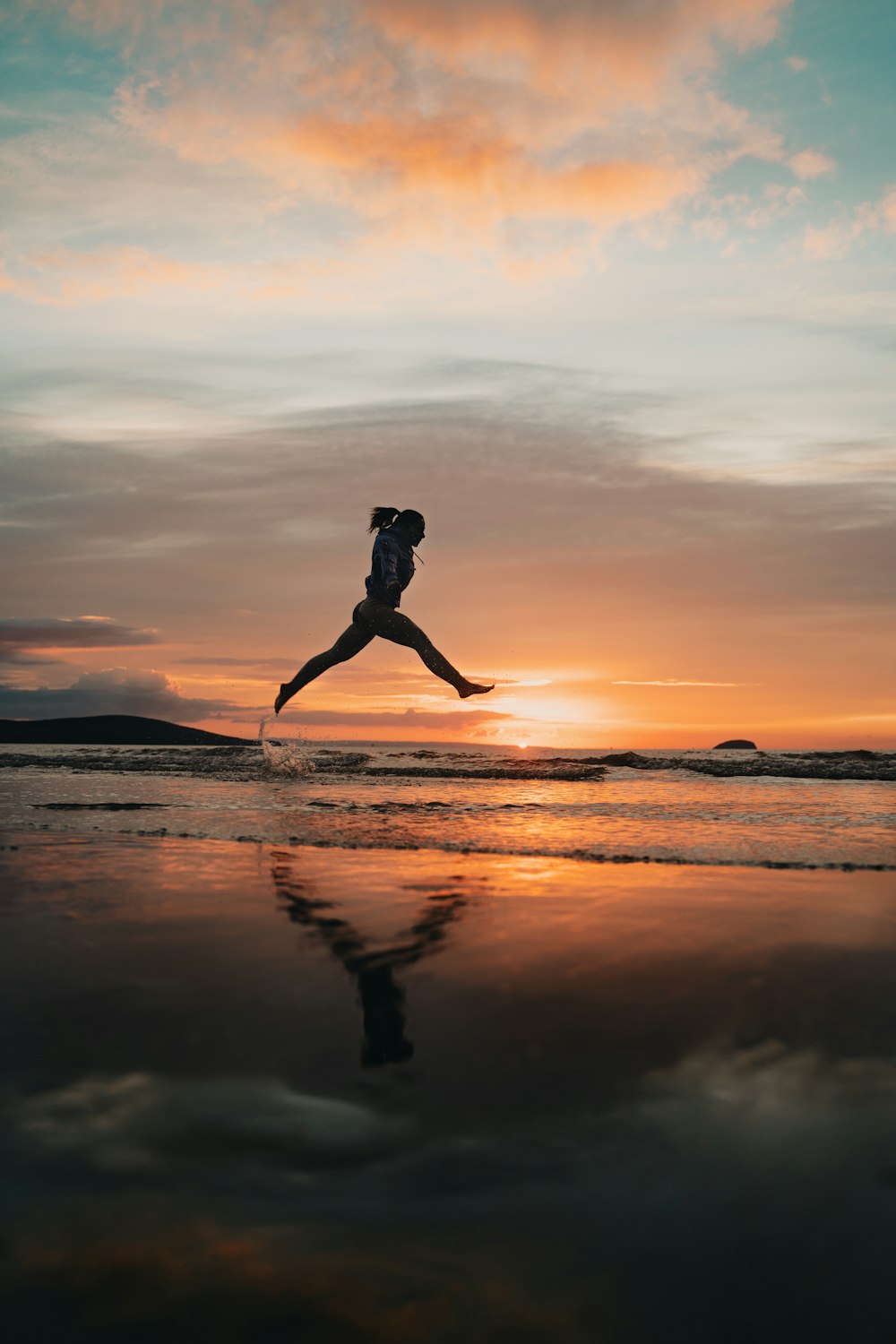 woman in black bikini standing on beach during sunset