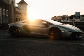 A sleek electric vintage car parked on a cobblestone street at sunset.