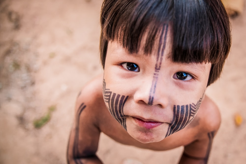 topless boy with black and white face paint